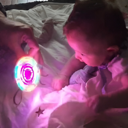 un bébé qui regarde un jouet lumineux